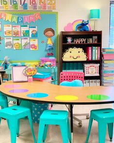 a classroom with tables, chairs and bookshelves filled with children's artwork