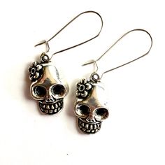 Discover your new favorite earrings today! These unique, stylish, and affordable silver tone skull earrings are the perfect gift for someone special or for treating yourself. Handcrafted with brass metal alloy, they have a gothic flair that sets them apart. Add a touch of Mexico to your outfit with these flowered skull earrings, inspired by the Day of the Dead. Perfect for women and girls, these lever back ear wires make a stunning addition to any jewelry collection. Don't miss out on this amazi Bohemian Skull Earrings For Gifts, Adjustable Gothic Skull Earrings, Skull-shaped Metal Earrings, Metal Skull Jewelry With Skull Print, Gothic Sterling Silver Skull Earrings, Punk Skull Print Earrings For Gift, Punk Skull Print Earrings Gift, Gothic Skull Metal Earrings, Punk Style Skull Print Earrings As Gift