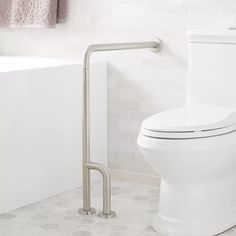 a white toilet sitting in a bathroom next to a bathtub and shower curtain rod