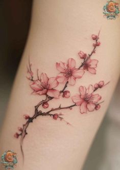 a woman's leg with pink flowers tattooed on the side of her thigh,