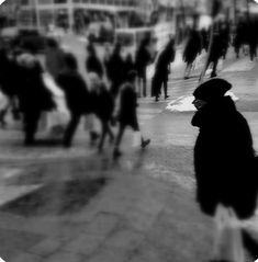 black and white photograph of people walking down the street