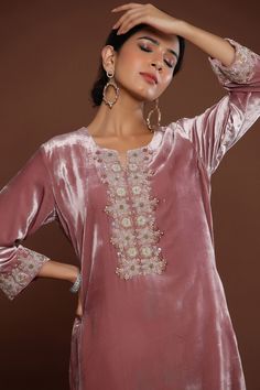 Pink velvet kurta with pearls, dabka, cutdana and resham embroidery. Comes with beige chanderi pant and an organza dupatta. Components: 3 Pattern: Embroidered Type Of Work: Pearls, Dabka, Cutdana, Resham Neckline: Round Sleeve Type: Full Fabric: Kurta : Velvet, Pants : Chanderi, Dupatta : Organza Color: Pink Other Details:  Elasticated waistband Attached lining Occasion: Mehendi and Haldi - Aza Fashions Cigratte Pants, Velvet Dresses, Pink Pearls