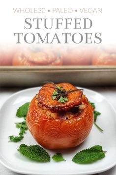 stuffed tomatoes on a white plate with mint garnish