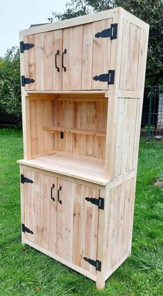 a wooden cabinet sitting on top of a lush green field