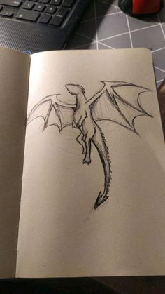 an open book with a drawing of a dragon on it