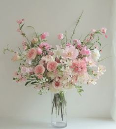 a vase filled with lots of pink and white flowers