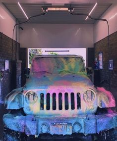 an old jeep is covered in colorful paint