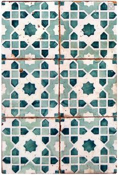 an old tiled wall with blue and white tiles on the bottom, in different shapes