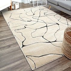 a white rug with black lines on it in a living room next to a couch