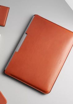 an orange leather ipad case sitting on top of a desk