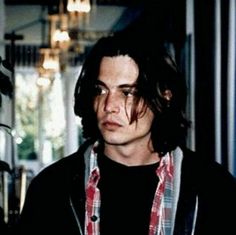 a man with long hair and glasses standing in front of a camera