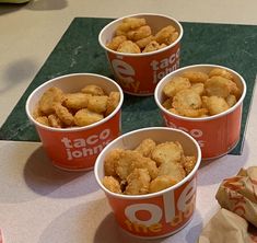 four red cups filled with food sitting on top of a counter