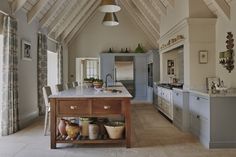 a kitchen with an island in the middle and lots of pots on top of it