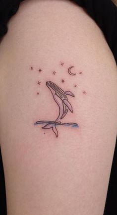 a tattoo on the back of a woman's shoulder with a dolphin jumping out of water