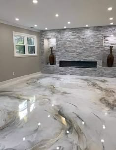 an empty room with white marble floors and gray brick wall behind the fireplace, surrounded by two vases