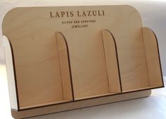 a wooden business card holder with four different sized cards on it's front and back sides