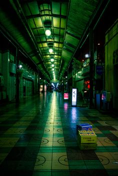 an empty subway station at night with lights shining on the floor and boxes in the middle