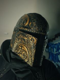 a close up of a person wearing a helmet with intricate designs on it's face