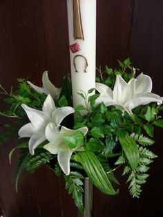 a white candle and some flowers in a vase