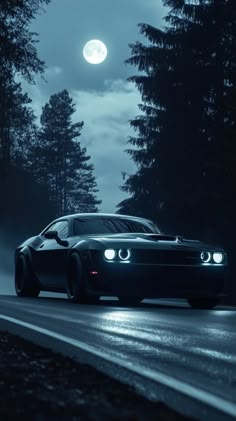 a black car driving down a road at night with the moon in the sky behind it