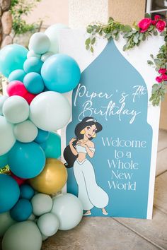 a welcome sign is surrounded by balloons and streamers