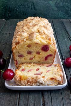 a loaf of fruit bread on a plate with cherries