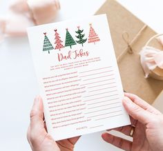 a person holding up a card that says dad - to - be with christmas trees on it