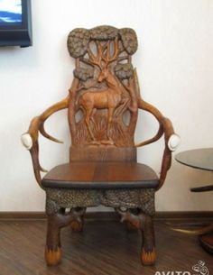 a wooden chair sitting on top of a hard wood floor next to a wall mounted tv