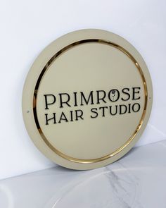 the primrose hair studio logo is shown on a white wall behind a glass plate