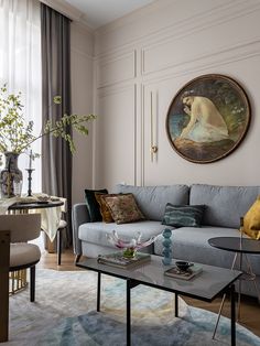 a living room filled with furniture and a painting hanging on the wall above a coffee table