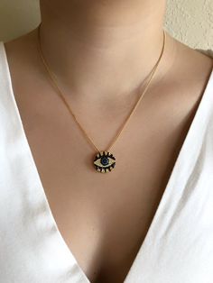 "Round Evil Eye Charm This is an 18K gold plating 2mm box chain necklace with a black and blue colored round cubic zirconia \"0.75 / 1.90 cm evil eye pendant. This is a simple but eye-catching necklace. It's a great look for daytime, clean line, fashion, and urban look, and could be a perfect birthday, mother's day or Christmas gift. Details: 18K Gold Plated 2mm box chain. 0.75\" / 1.90 cm Evil Eye 18K gold plated pendant. Approximate length: 17.2\" or 45 cm. Each item is carefully shipped in an Gold Plated Evil Eye Round Pendant Jewelry, Gold Plated Evil Eye Jewelry, Cubic Zirconia Box Chain Necklace For Gift, Cubic Zirconia Box Chain Necklace As Gift, Gift Necklace With Cubic Zirconia And Box Chain, Spiritual Round Cubic Zirconia Necklace, Black Round Pendant Necklace, Gold Plated, Black Round Pendant Necklace In Gold Plated, Black Gold Plated Round Pendant Necklace