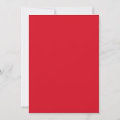 a red card with white envelope on a marble surface