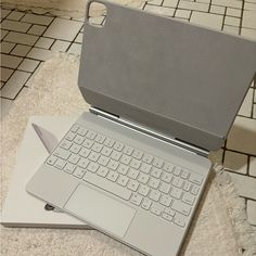 an open laptop computer sitting on top of a white table next to a mouse pad