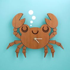 a clock made out of wood with a crab on it's face and hands