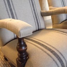 a close up of a chair with pillows on the back and armrests that are turned down