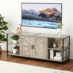 an entertainment center with a flat screen tv mounted on the wall next to a potted plant