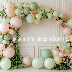 balloons and greenery are arranged in the shape of a letter