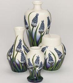 four white vases with blue flowers on them