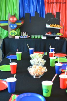 the table is set up with cups, plates and candy bars for children's birthday party