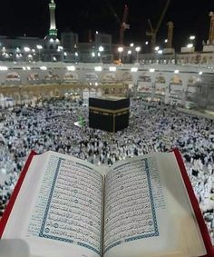 an open book sitting on top of a table in front of a crowd of people