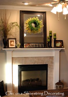 a mantel with a wreath on top of it and other decorations around the fireplace