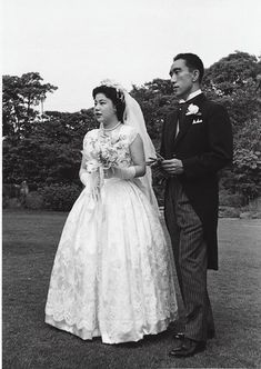 an old photo of a man and woman in wedding attire standing next to each other