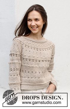 a woman is smiling while wearing a sweater