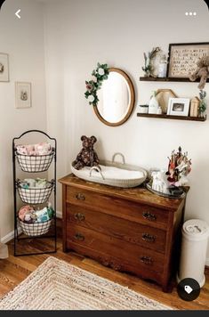 a wooden dresser sitting next to a mirror in a room on top of a hard wood floor