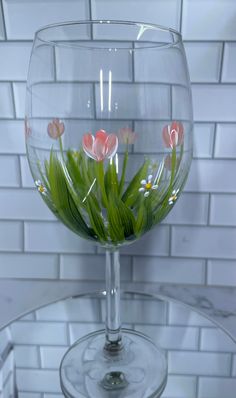 a wine glass with flowers in it sitting on a table