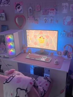 a desk with a computer, keyboard and headphones on it in front of a wall full of pictures