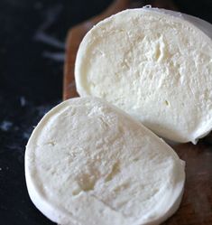 two pieces of cheese sitting on top of a cutting board