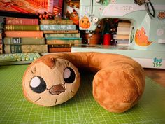 a stuffed animal is sitting on a table next to a sewing machine and several books