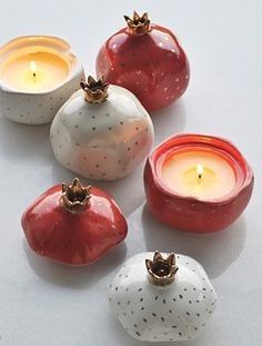 small ceramic apples and candles on a white surface