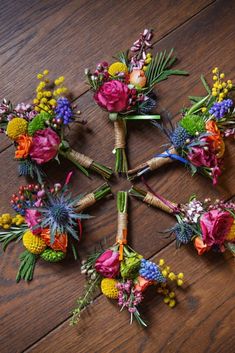 a bunch of flowers arranged on top of a wooden table